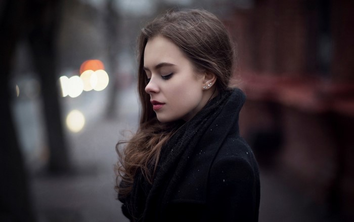 Woman in black coat with brown hair