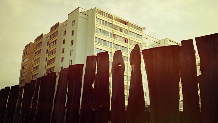 Apartment building behind a wooden fence
