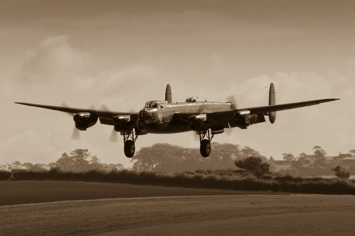 Avro Lancaster bomber flying over a field