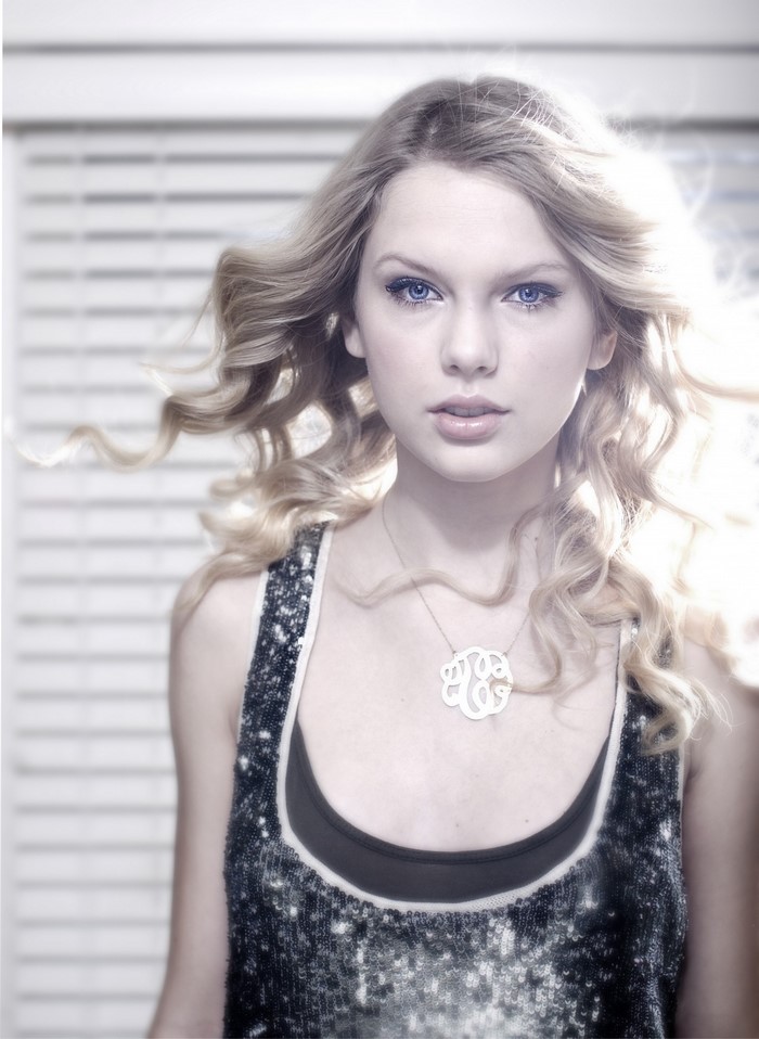 Taylor Swift wearing a sequined top and monogram necklace