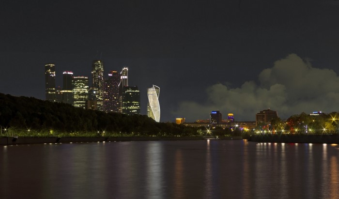 Moscow City skyline at night with river reflection