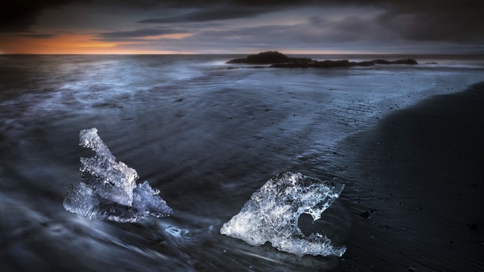 Ice chunks on black sand beach at sunset, Iceland