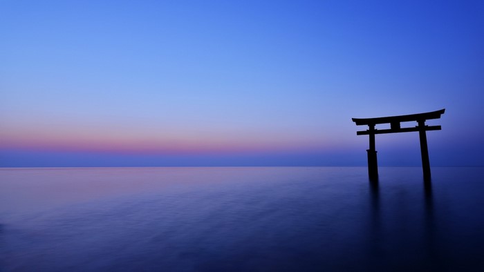 Torii gate in the ocean at sunset