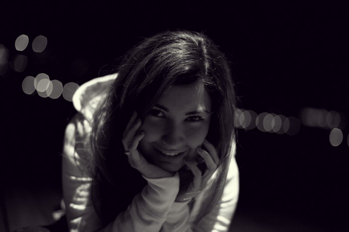Monochrome portrait of a woman in a hoodie at night