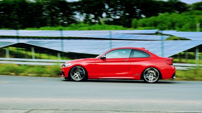 Red BMW sports car driving on a road