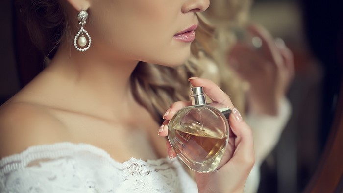 Woman applying perfume on her neck