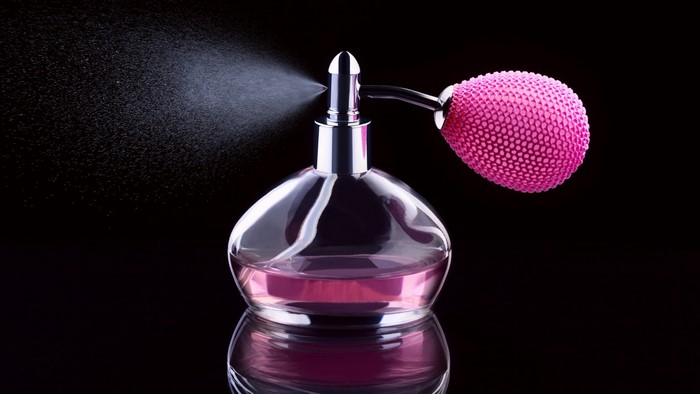 Perfume bottle with pink bulb sprayer and pink liquid