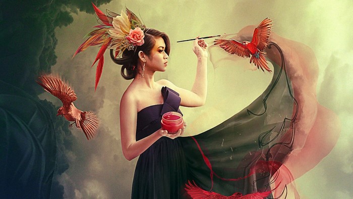Woman painting red birds with a brush