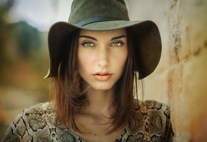 Woman wearing a hat and snake print shirt