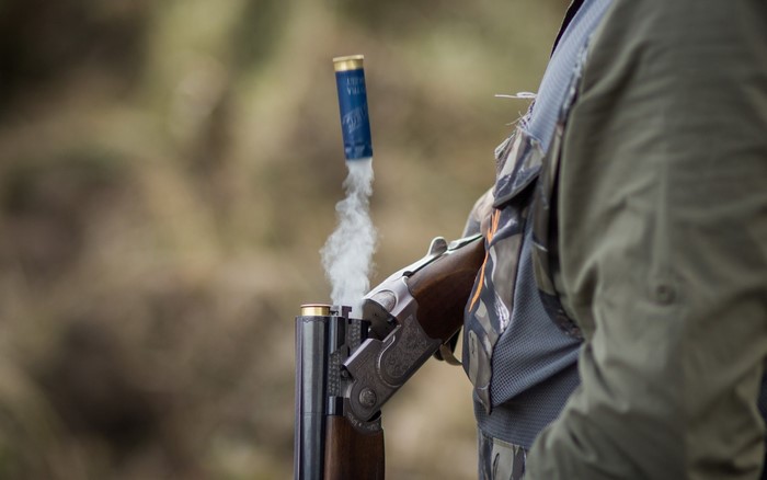 Man ejecting shotgun shell after firing