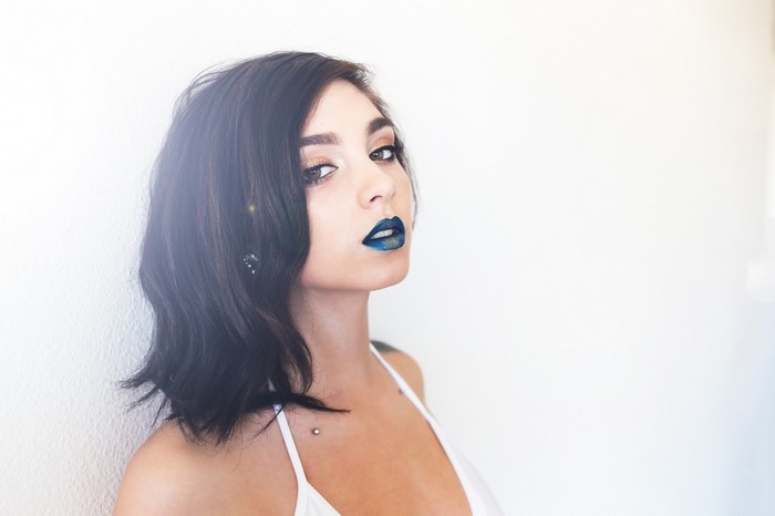 Woman with dark hair and blue lipstick