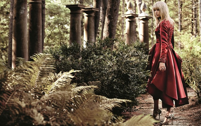 Taylor Swift in a red dress in a forest