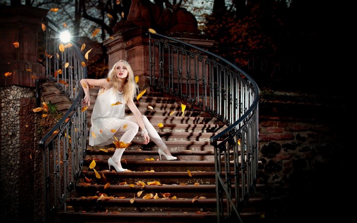 Woman in white dress on autumn stairs at night