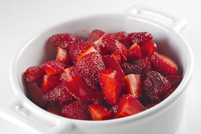 Chopped strawberries in a white bowl
