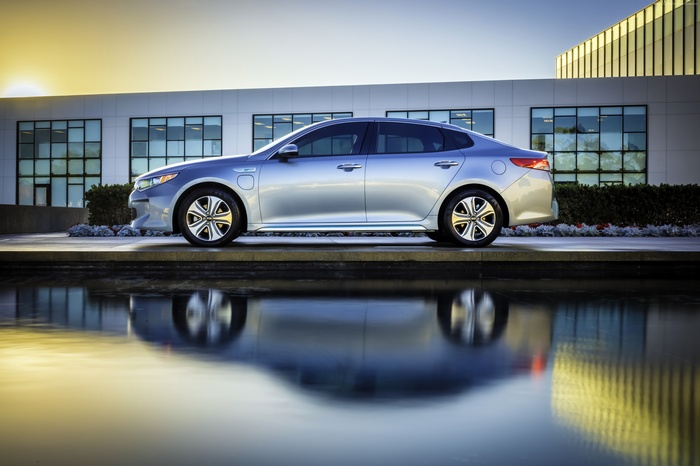 Silver Kia Optima Plug-In Hybrid by a modern building