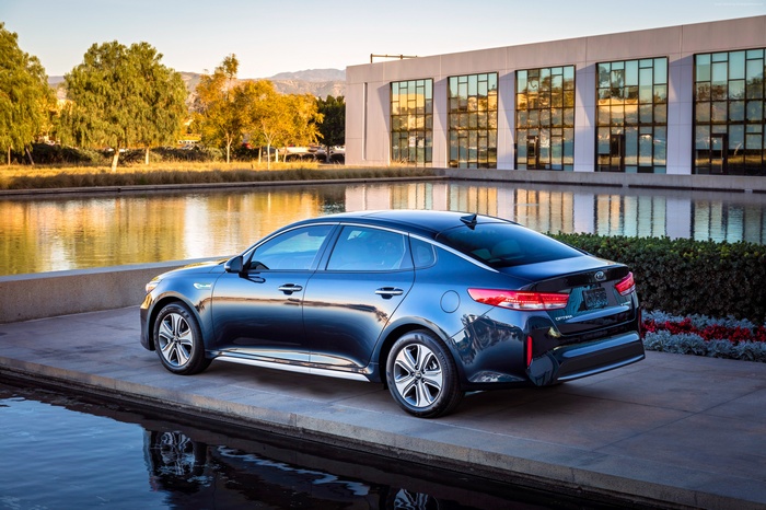 Kia Optima Hybrid parked by a building and water