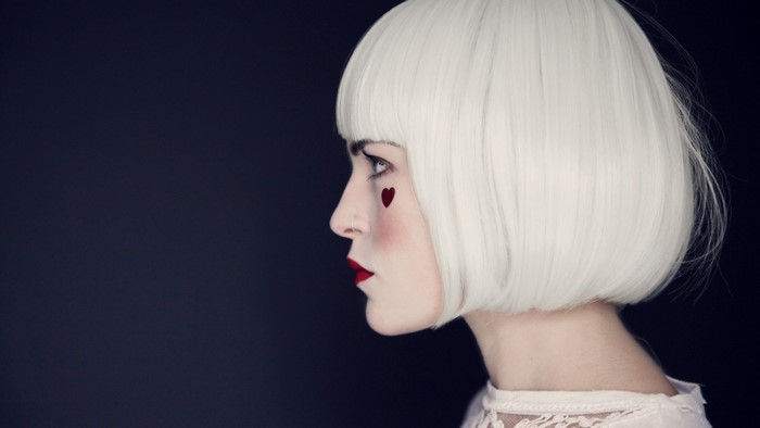Woman with white wig and heart makeup in profile