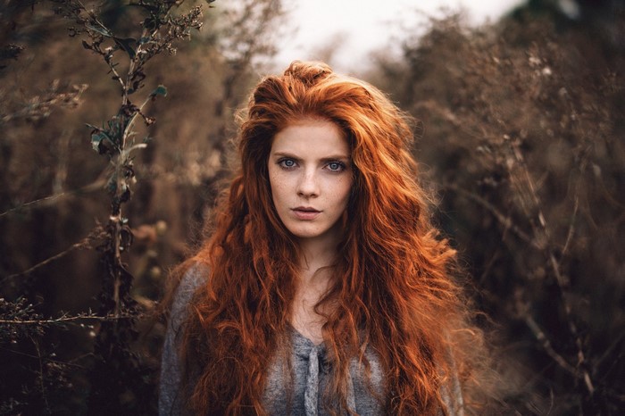 Redhead woman with blue eyes and freckles in nature