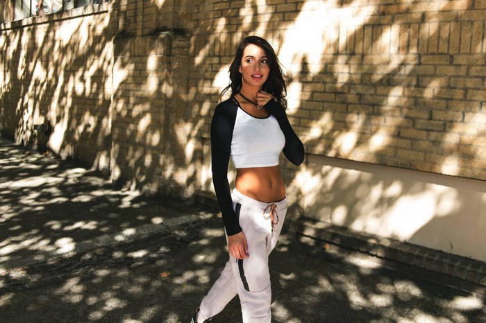 Woman in crop top and sweatpants walking outdoors