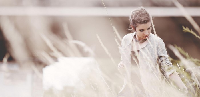 Woman in a light jacket and dress in a field