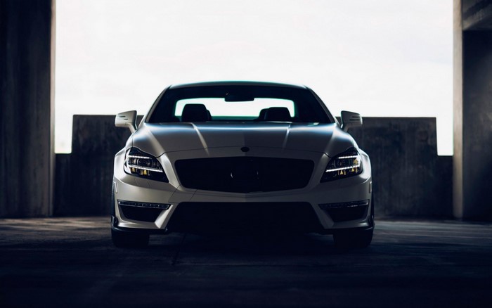 White Mercedes-Benz CLS parked in a concrete structure