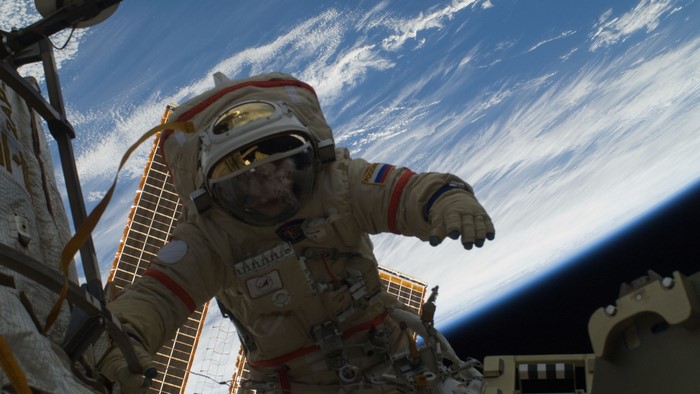 Astronaut in a spacesuit with Russian flag in orbit
