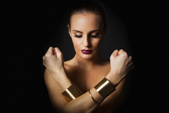 Woman with gold bracelets and dark lipstick