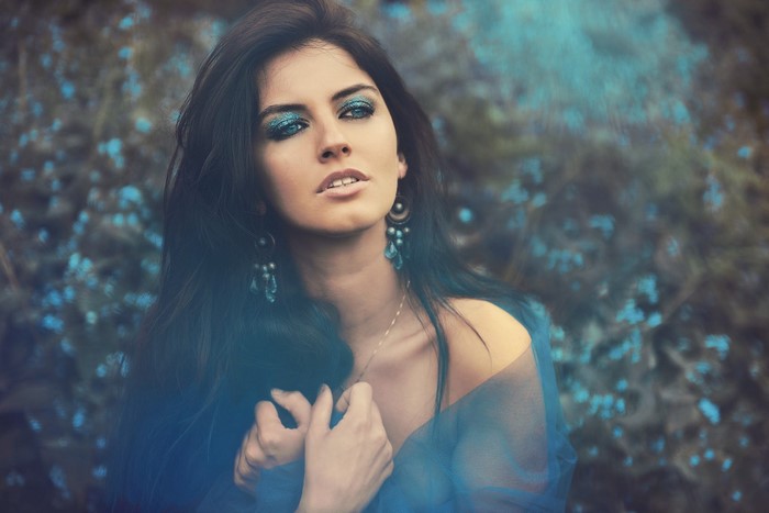Woman with blue eyeshadow and earrings