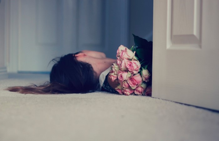 Woman lying on floor with pink roses