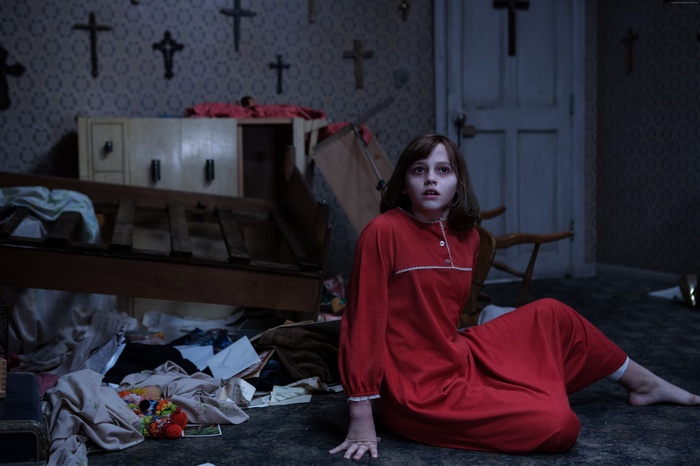 The Conjuring 2: A young girl in a red dress sits on the floor