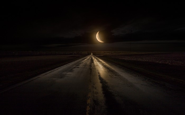 Crescent Moon over a Wet Road at Night