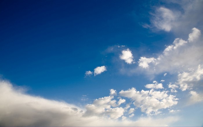 Blue sky with scattered white and gray clouds