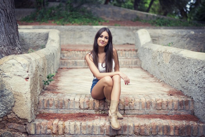 Young Woman Sitting on Brick Steps Outdoors