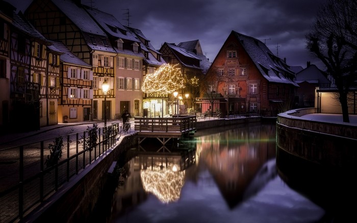 Winter night canal with illuminated buildings and Christmas lights