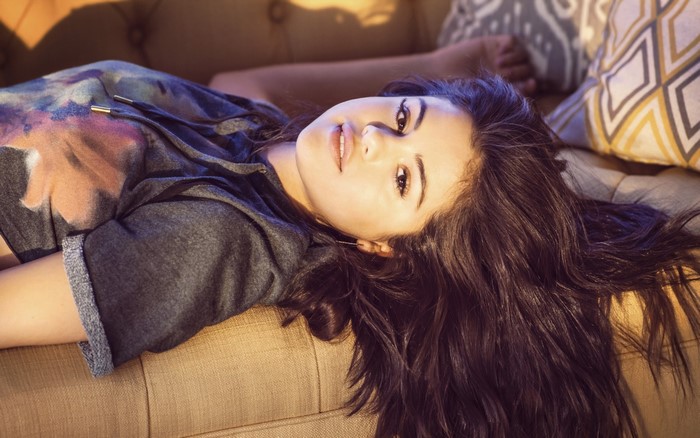 Selena Gomez lying on a couch