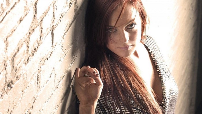 Lindsay Lohan leaning against a brick wall