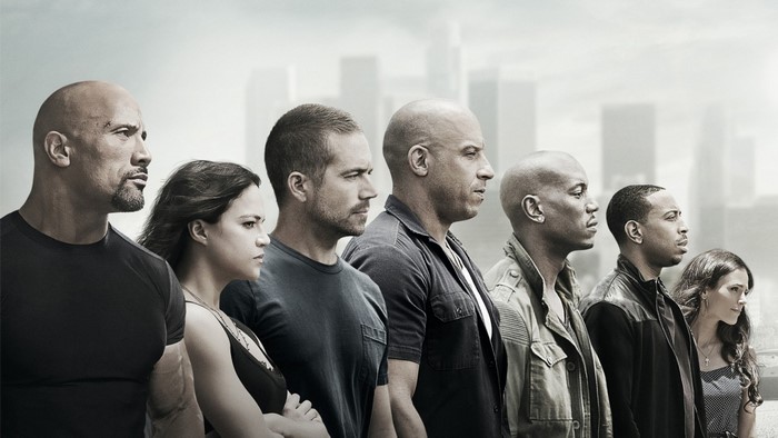 Fast and Furious cast standing in front of city skyline