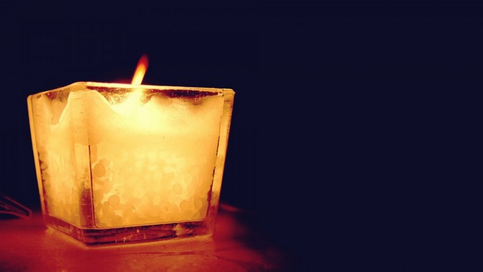 Candle with a flame in a glass holder