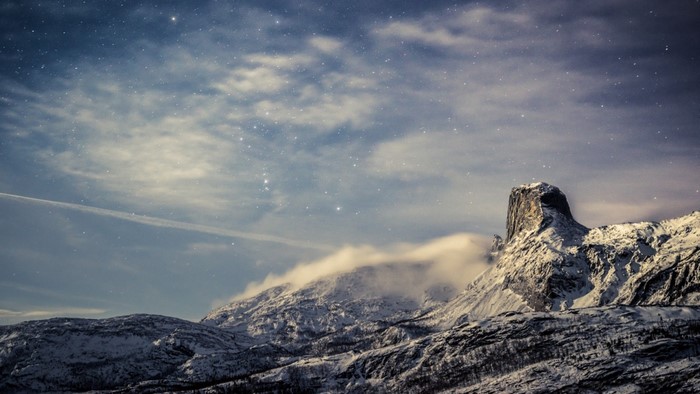 Snowy mountains under a starry night sky