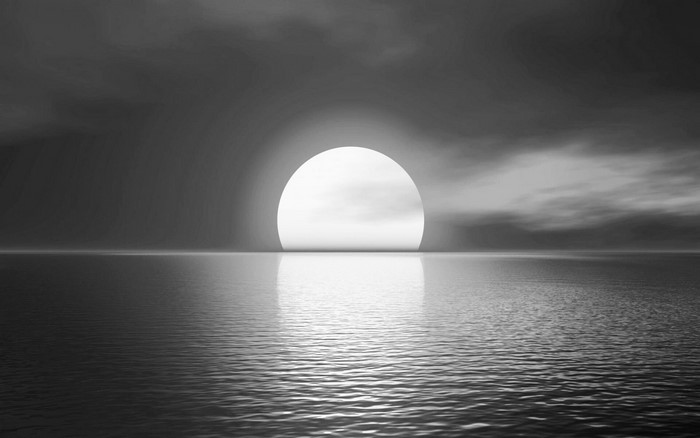 Sun setting over the ocean with reflection