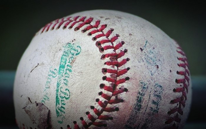 Close up of a worn baseball with red stitching