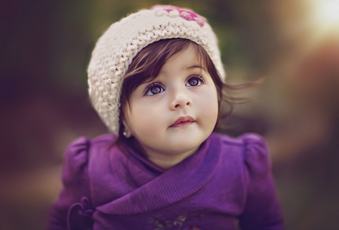 Adorable Toddler Girl with Bright Eyes in Purple Outfit