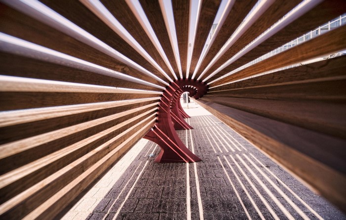 Wooden bench with sunlit patterns on the ground