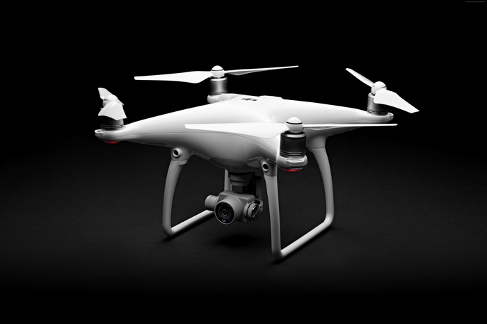 White DJI Phantom 4 Drone on Black Background