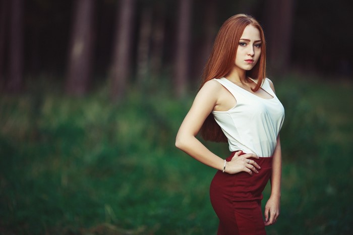 Woman with long red hair in a white top and red skirt