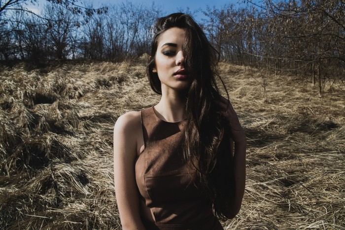 Woman in brown dress in dry grass field