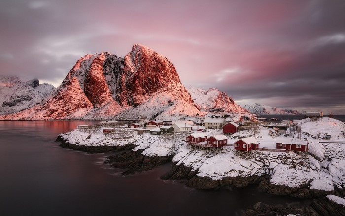 Snowy Norwegian village at sunrise with mountains