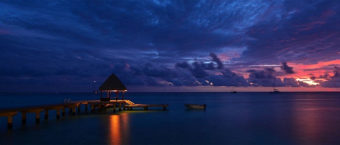 Pier with gazebo over the ocean at sunset