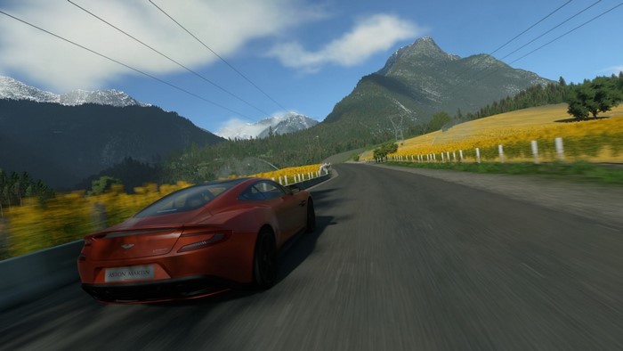 Aston Martin sports car driving on a scenic mountain road
