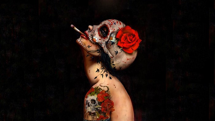 Woman with skull face paint and rose